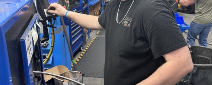 Technician measuring and cutting hose at a production station